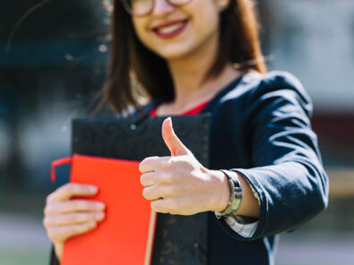 Frau zeigt Daumen nach Prüfung