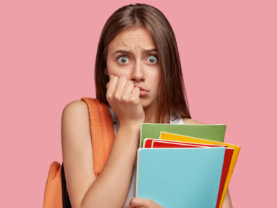 Frau mit Mappen in der Hand macht auf Angsthase