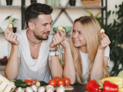 glückliches Pärchen vor Gemüse zum gemeinsamen Kochen
