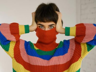 Frau im gestreiften Pulli versteckt sich hinter dem Rollkragen