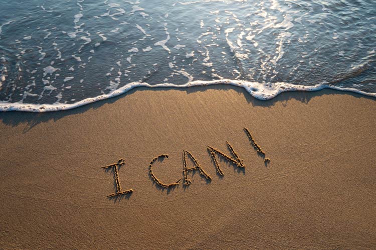 im Sand am Strand steht I CAN und das Wasser wird angespühlt