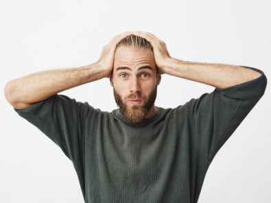 ein Mann hält sich die Hände überfordert über dem Kopf zusammen